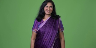 成熟快乐美丽的印度女人微笑着，而穿着传统的纱丽衣服