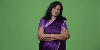 成熟快乐美丽的印度女人双臂交叉穿着传统的纱丽衣服