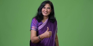 成熟快乐美丽的印度女人在穿着传统的纱丽衣服时竖起大拇指