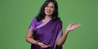 成熟快乐美丽的印度女人说话时，穿着传统服装莎丽