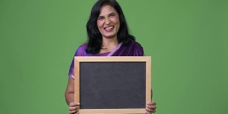 成熟快乐美丽的印度女人微笑着展示黑板