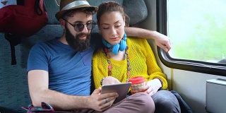 夫妇在火车上浏览平板电脑