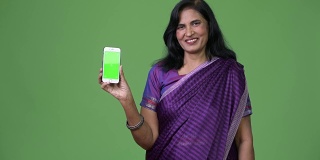 成熟快乐美丽的印度女人微笑着展示手机