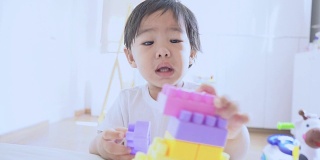 亚洲婴儿玩彩色塑料砖