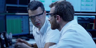 两个IT程序员正在一间办公室里用电脑工作。用RED EPIC电影摄影机慢动作拍摄。