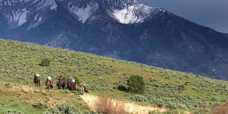 牛仔和女牛仔骑马穿过歌珊谷，犹他州