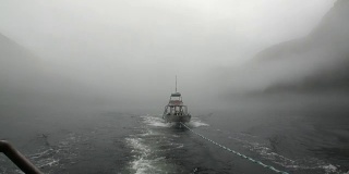 拖船在雾在太平洋的水在背景山脉阿拉斯加。