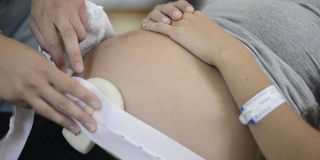 孕妇正在接受宫缩监测和静脉注射。