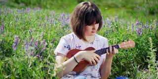 年轻漂亮的女孩在弹尤克里里吉他
