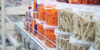 一位妇女在一家建筑用品商店里挑选波纹塑料插头。
