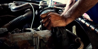 机修工用扳手在车库里修理汽车发动机