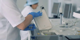 护士在现代化的实验室里用专用机器做了测试后取瓶样本。