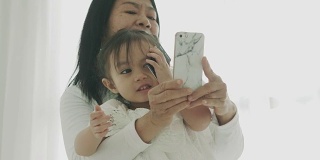 泰国母女用智能手机自拍泰国家庭的现代生活方式