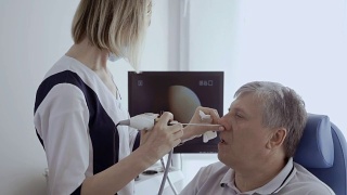 医生用耳鼻喉望远镜检查老人的鼻子视频素材模板下载