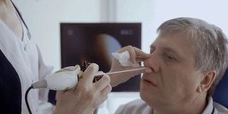 医生用耳鼻喉镜检查病人的鼻子