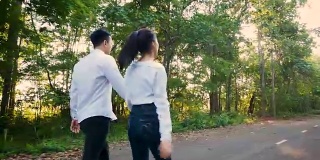 相爱的年轻夫妇喜欢在户外公园散步，手牵着手