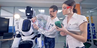 人们在机器人上用安培表工作。