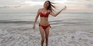 年轻美丽的亚洲女人在海滩摆姿势