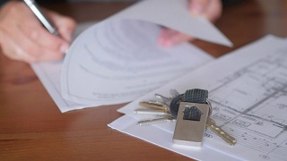 阅读和签订买房、租房、公寓、带钥匙的合同视频素材模板下载