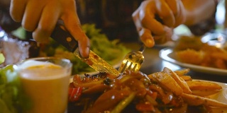 在豪华餐厅里由亚洲妇女用刀切的牛排。健康饮食与饮食观念。