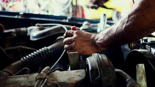 机修工用扳手在车库里修理汽车发动机视频素材模板下载