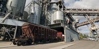 以农作物作为货物运输的货运列车在近海大型粮食码头行驶。将粮食从铁路车厢卸到升降机。粮食中转设施枢纽仓