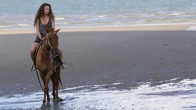 在海边骑马的年轻女子