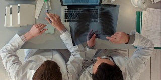 俯视图医生讨论肠道x光在医疗办公室