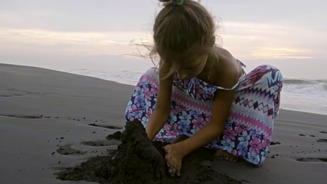 小女孩在沙滩上玩湿沙