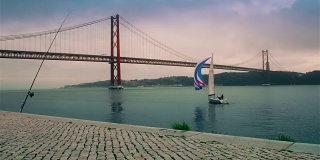 4月25日，一艘漂亮的游艇在里斯本大桥附近的塔古斯河上航行