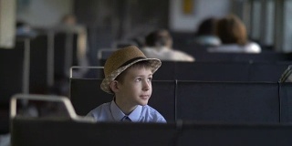 快乐的男孩坐在火车上望着窗外，梦想着什么
