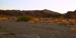夕阳西下，驱车行驶在沙漠路上的美丽画面