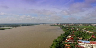 空中:飞回来，映出河边的村庄，云的影子掠过湄公河