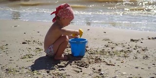 全高清观看儿童在沙滩上玩快乐的白人小女孩，孩子玩的桑迪玩具