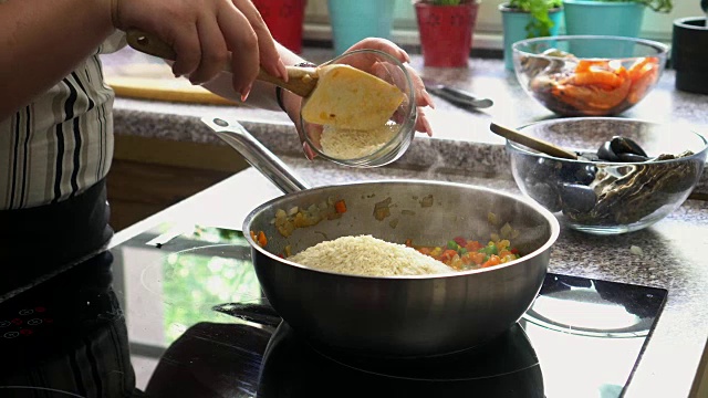 年轻女子准备海鲜饭