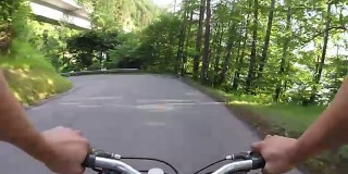 骑自行车的人沿着乡间小路穿过森林