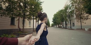 年轻夫妇牵着女人的手牵着男朋友走在大街上