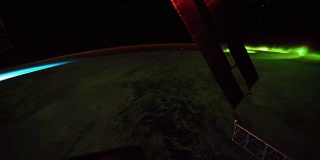 在地球北极上空看到的明亮的绿色极光。前景中可以看到国际空间站的太阳能电池板。图片由美国宇航局约翰逊航天中心地球科学和遥感单元提供。由Rebus_Prod处理。