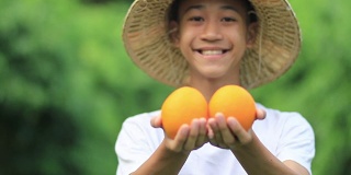农民手上挂着橘子，脸上挂着笑容