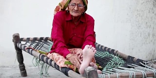 坐在Charpai上的老妇人
