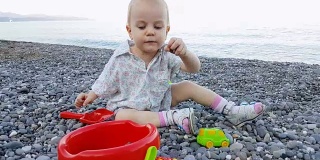 小男孩暑假在海滩上玩鹅卵石
