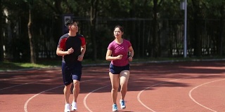 年轻的亚洲夫妇在体育场慢跑