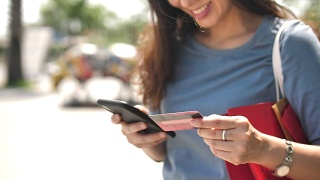 购物女性使用智能手机和信用卡购物袋视频素材模板下载