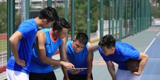 一组亚洲青年篮球运动员讨论战术