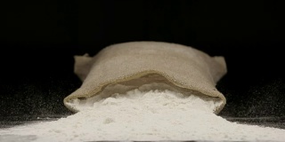 慢镜头:一个撒着麦粉的袋子掉在桌子上
