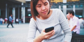 一名女子在香港街头使用智能手机