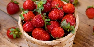 篮子里的新鲜草莓在木桌上旋转