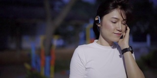 运动女性用无线耳机听音乐的慢镜头