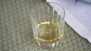 服务员把冰块放在一个有威士忌的杯子里，一杯威士忌放在桌子上，一杯威士忌放冰块，一杯威士忌加冰在桌子上视频素材模板下载
