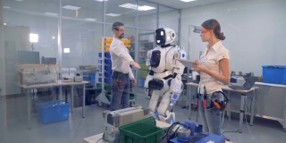 一组工程师正在通过手势和电脑来指导机器人的动作